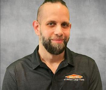 Man wearing a black shirt in front of wall