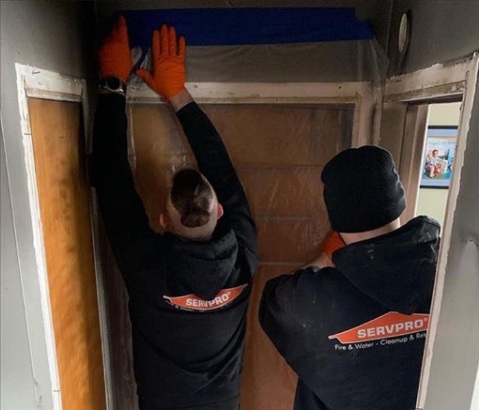 SERVPRO workers containing the affected area.