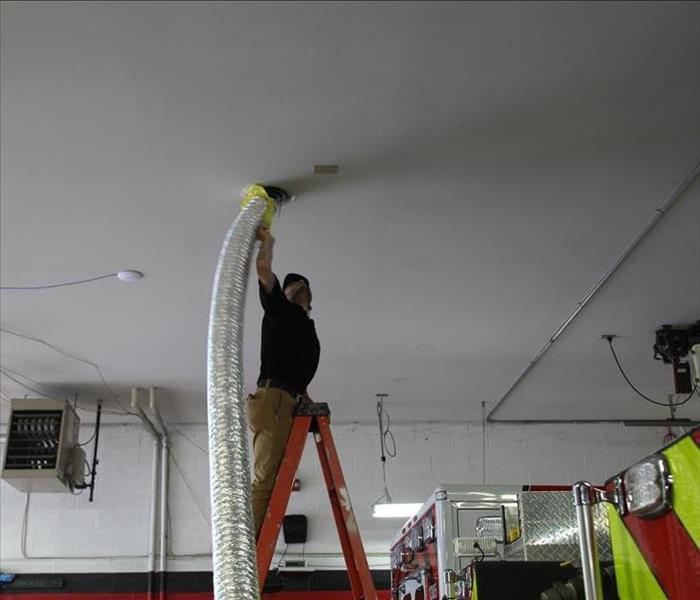 SERVPRO worker on a ladder